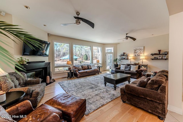 living room with light wood-type flooring and ceiling fan