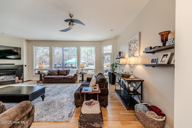 living room featuring ceiling fan and light hardwood / wood-style floors