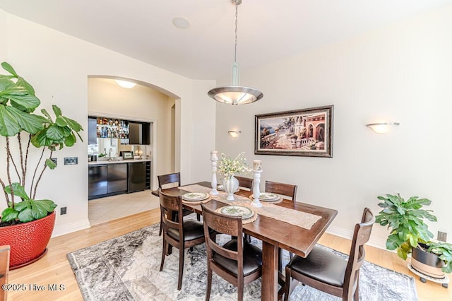 dining area with hardwood / wood-style floors and beverage cooler