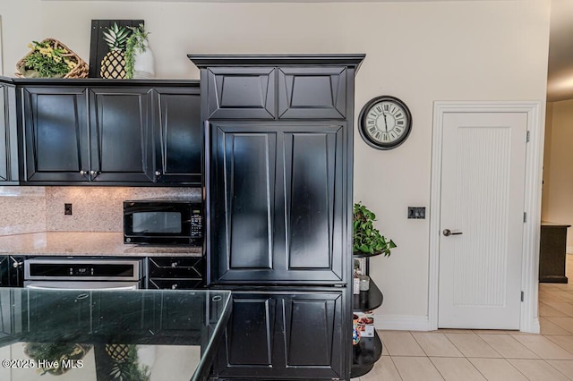 kitchen with wall oven, light stone counters, tasteful backsplash, and light tile patterned flooring