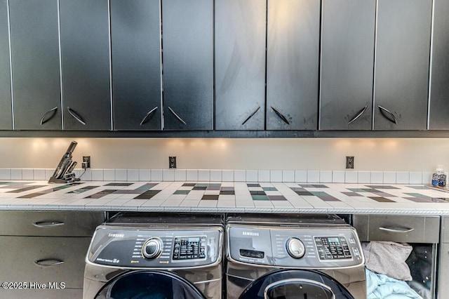 clothes washing area featuring cabinets and independent washer and dryer