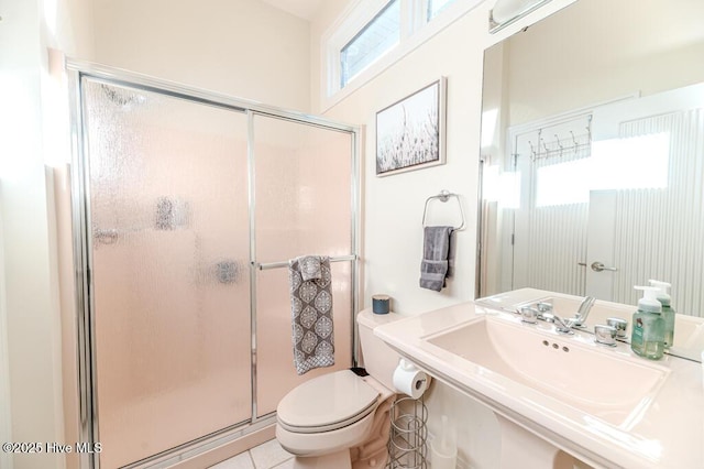 bathroom with tile patterned flooring, toilet, walk in shower, and sink