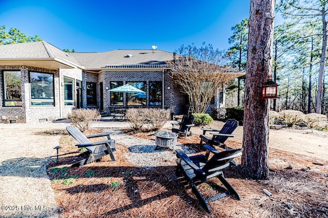 rear view of property featuring a fire pit and a patio area