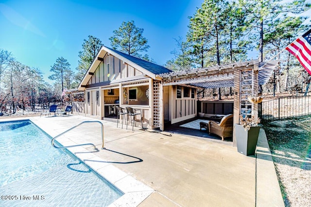 rear view of house featuring outdoor lounge area, a patio area, a pergola, and exterior bar