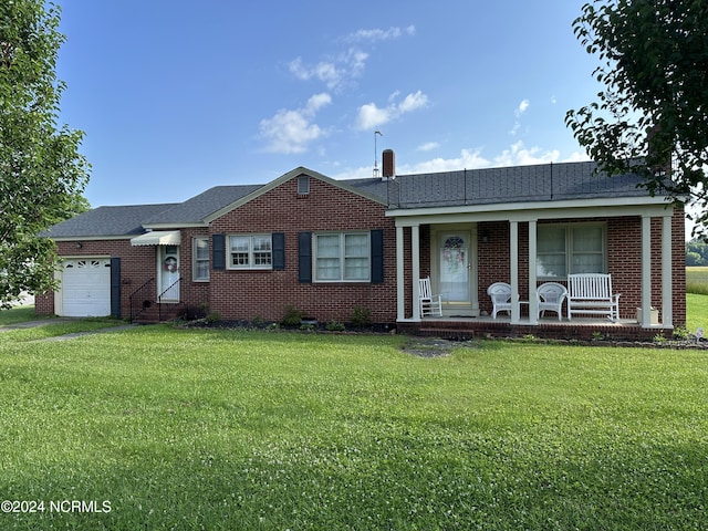 ranch-style home featuring a front lawn, covered porch, and a garage