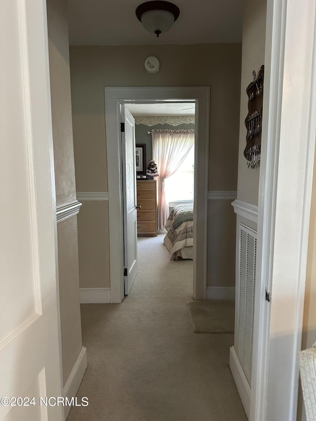 hallway featuring light colored carpet