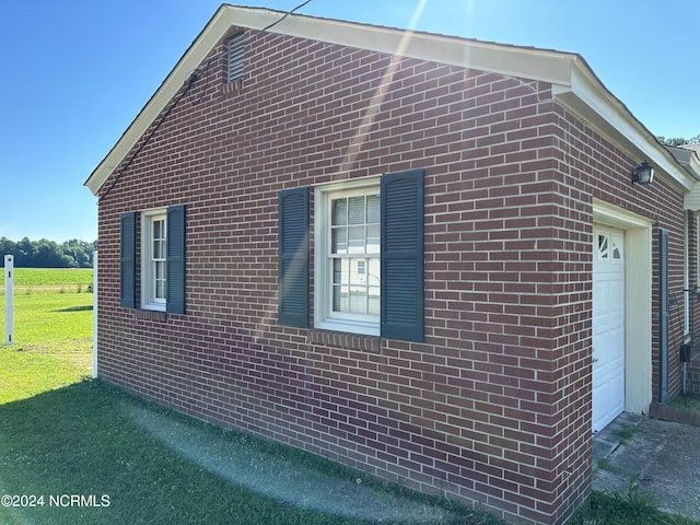 view of side of home with a lawn and a garage