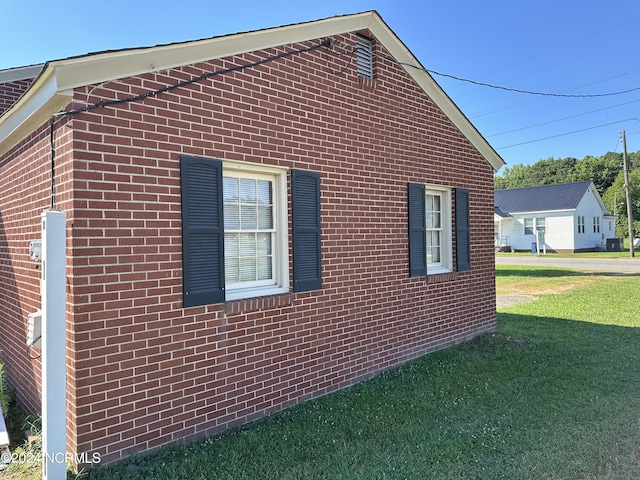 view of side of home with a yard