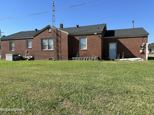 rear view of house with a yard and central air condition unit