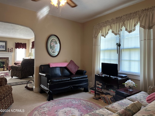 carpeted living room featuring a fireplace, a wealth of natural light, and ceiling fan