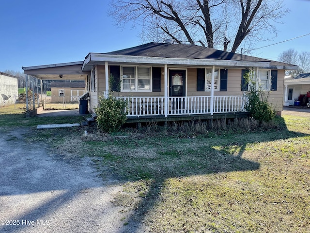 view of front of house with a carport, covered porch, and a front lawn