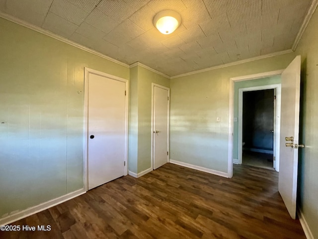 unfurnished bedroom featuring ornamental molding, dark wood-type flooring, and a closet