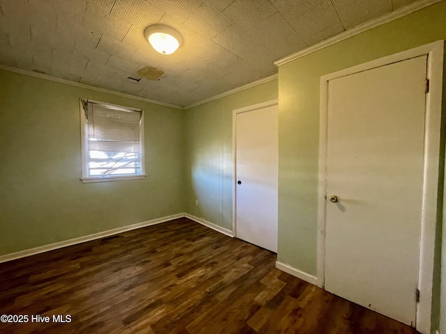 unfurnished bedroom featuring dark hardwood / wood-style floors and ornamental molding