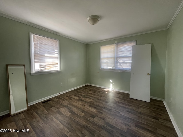 spare room featuring crown molding and dark wood-type flooring