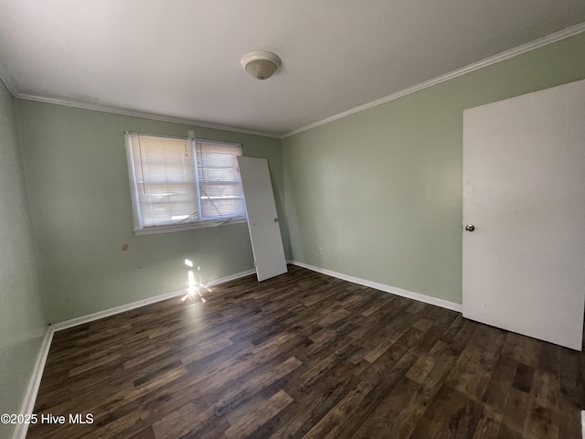 unfurnished room featuring ornamental molding and dark wood-type flooring