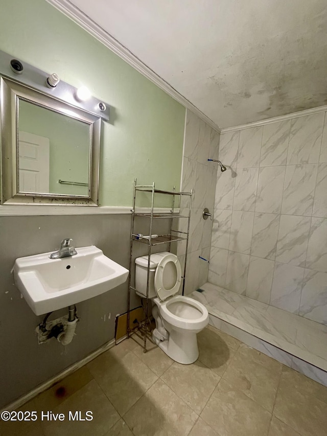 bathroom with sink, tile patterned flooring, toilet, ornamental molding, and a tile shower