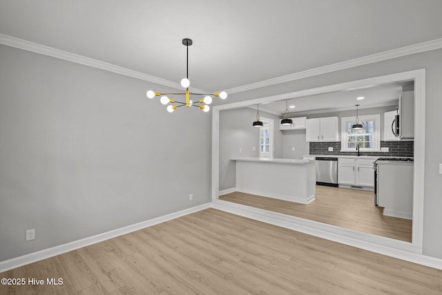 kitchen featuring pendant lighting, backsplash, white cabinetry, a chandelier, and stainless steel appliances