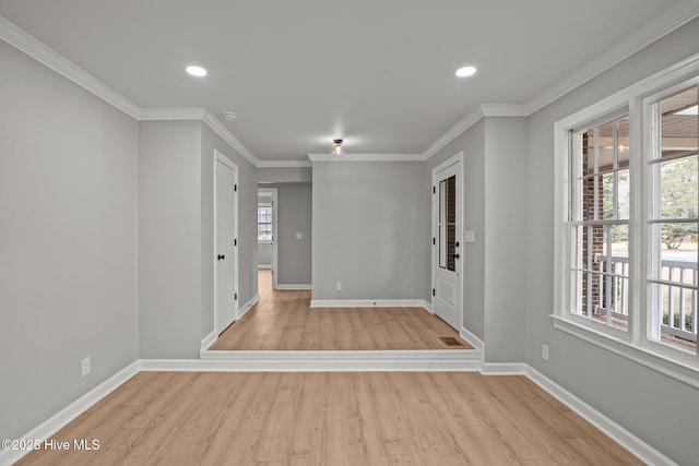 empty room featuring light wood-type flooring and ornamental molding