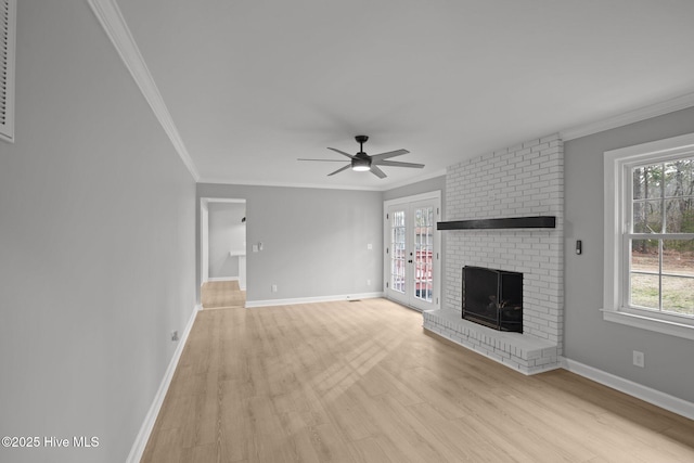 unfurnished living room with a brick fireplace, a wealth of natural light, and ornamental molding