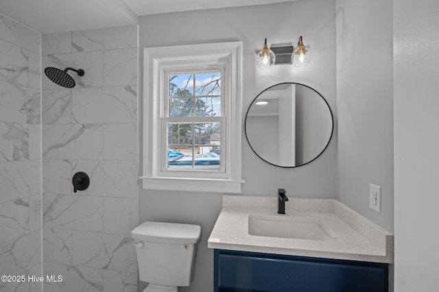 bathroom with vanity, toilet, and a tile shower