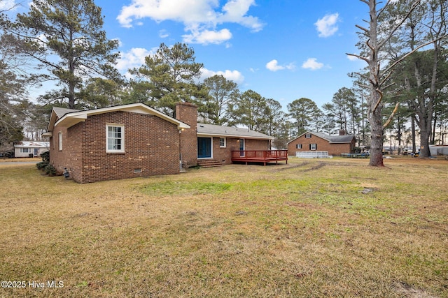 rear view of property featuring a deck and a yard