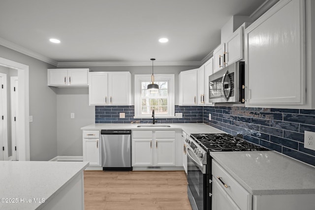 kitchen with white cabinetry, hanging light fixtures, and appliances with stainless steel finishes