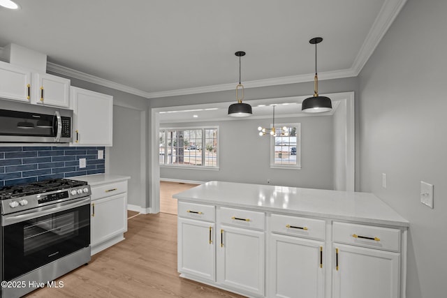 kitchen featuring tasteful backsplash, white cabinetry, decorative light fixtures, light hardwood / wood-style flooring, and stainless steel appliances