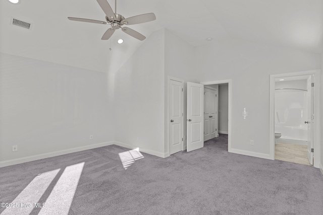 unfurnished bedroom with high vaulted ceiling, light colored carpet, ceiling fan, and ensuite bathroom