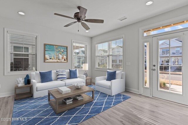 interior space featuring ceiling fan, pendant lighting, white cabinetry, light hardwood / wood-style floors, and a kitchen island