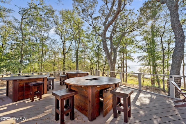 deck featuring a jacuzzi and an outdoor bar