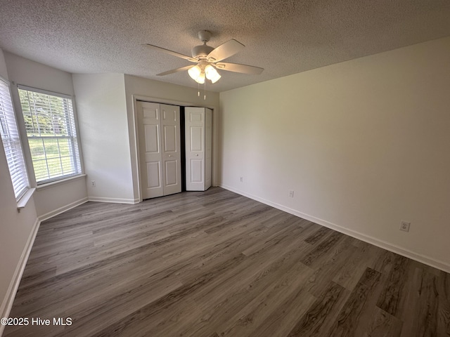 unfurnished bedroom featuring a textured ceiling, a closet, ceiling fan, and hardwood / wood-style flooring