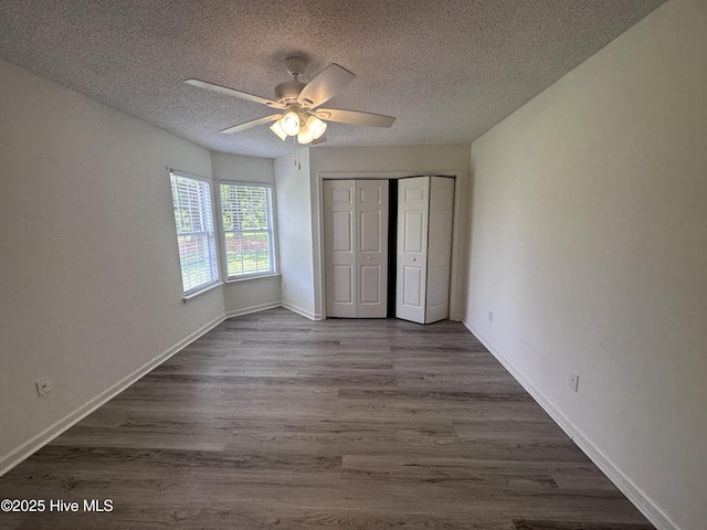 unfurnished bedroom with hardwood / wood-style floors, ceiling fan, a textured ceiling, and a closet