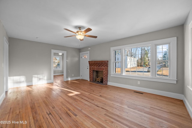 unfurnished living room with a fireplace, light hardwood / wood-style flooring, and ceiling fan