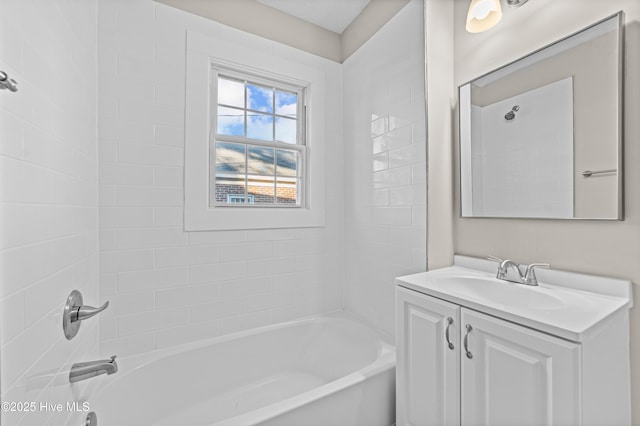 bathroom with tiled shower / bath combo and vanity