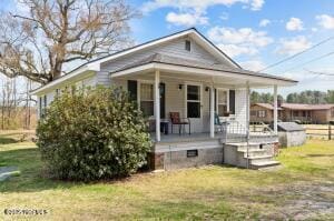 view of front of home with covered porch and a front lawn