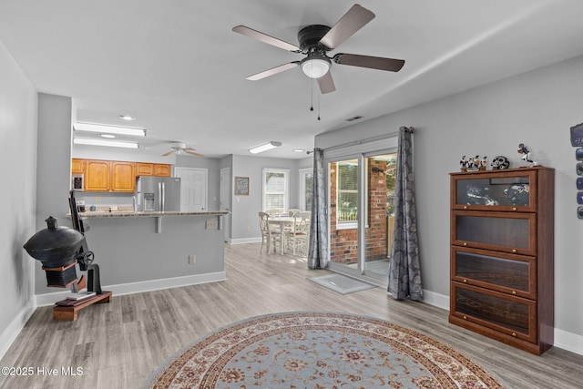 living room featuring ceiling fan and light hardwood / wood-style flooring