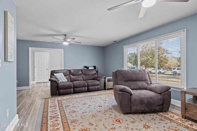 living room featuring ceiling fan and light hardwood / wood-style floors