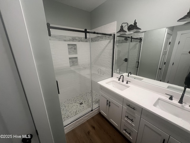 bathroom featuring hardwood / wood-style floors, vanity, and walk in shower