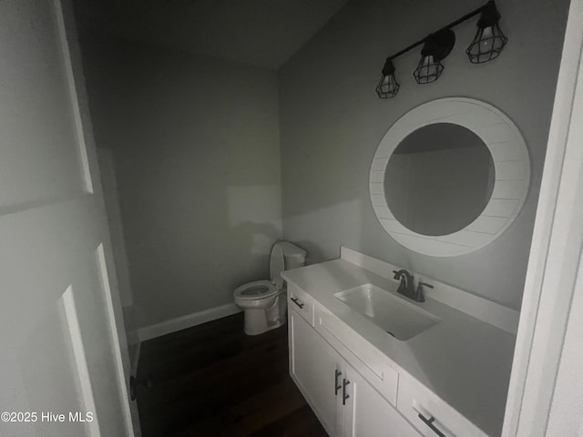 bathroom with hardwood / wood-style floors, vanity, and toilet