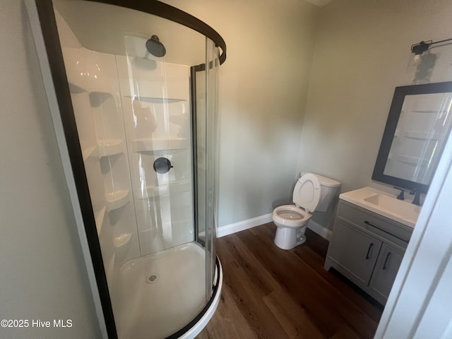 bathroom with vanity, toilet, an enclosed shower, and wood-type flooring