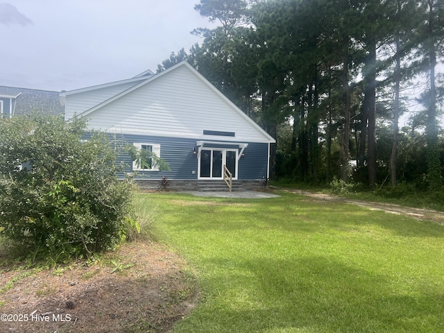 rear view of house featuring a yard