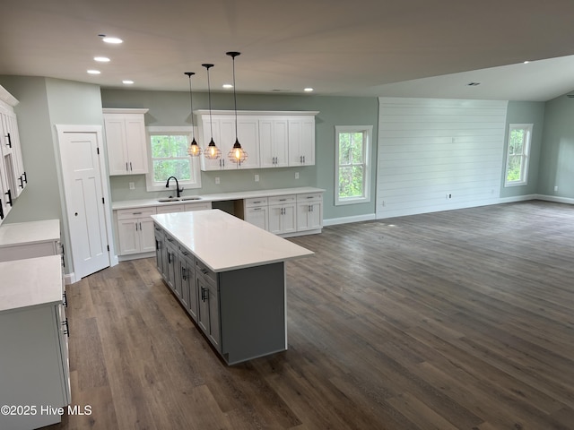 kitchen featuring gray cabinetry, white cabinetry, a center island, sink, and decorative light fixtures