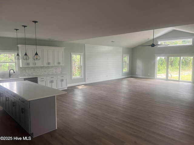 kitchen featuring a wealth of natural light, white cabinetry, a center island, sink, and backsplash