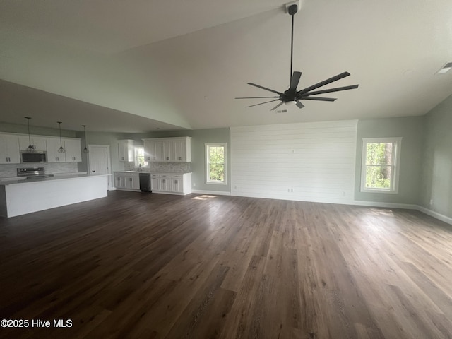 unfurnished living room featuring dark hardwood / wood-style flooring, ceiling fan, a healthy amount of sunlight, and sink