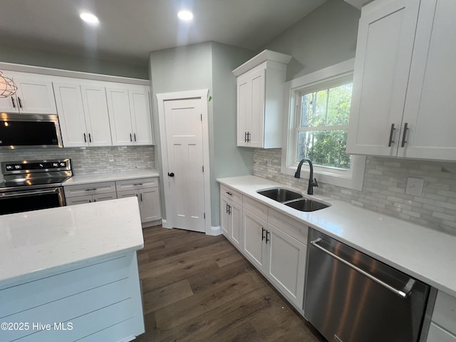 kitchen with sink, appliances with stainless steel finishes, dark hardwood / wood-style flooring, light stone counters, and white cabinetry