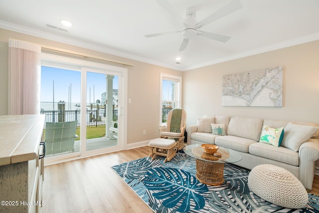 living room featuring ceiling fan, light wood-type flooring, and ornamental molding