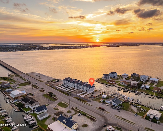 aerial view at dusk featuring a water view