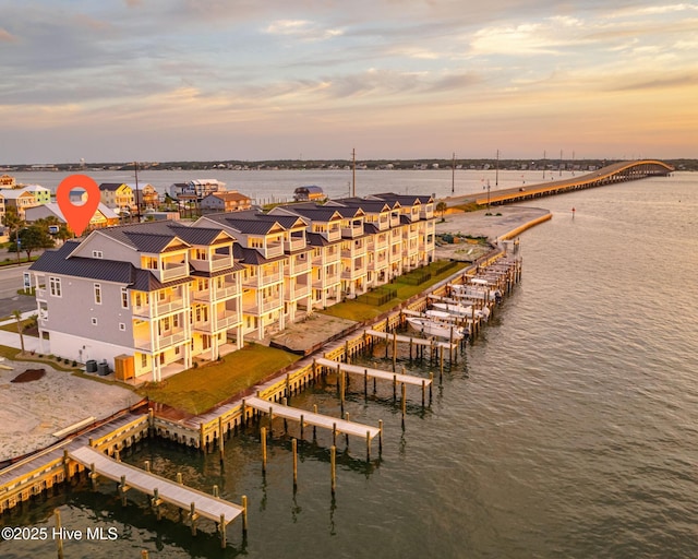 aerial view at dusk featuring a water view