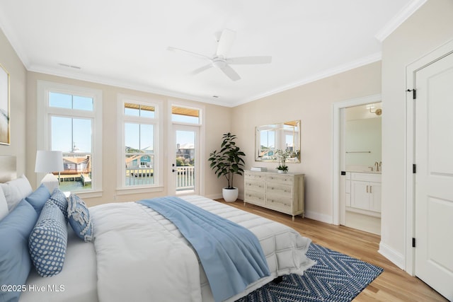 bedroom featuring ceiling fan, light hardwood / wood-style floors, ensuite bath, and multiple windows