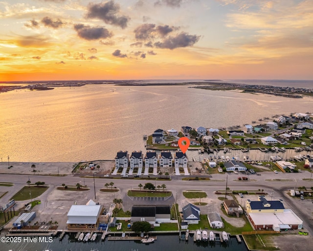 aerial view at dusk featuring a water view